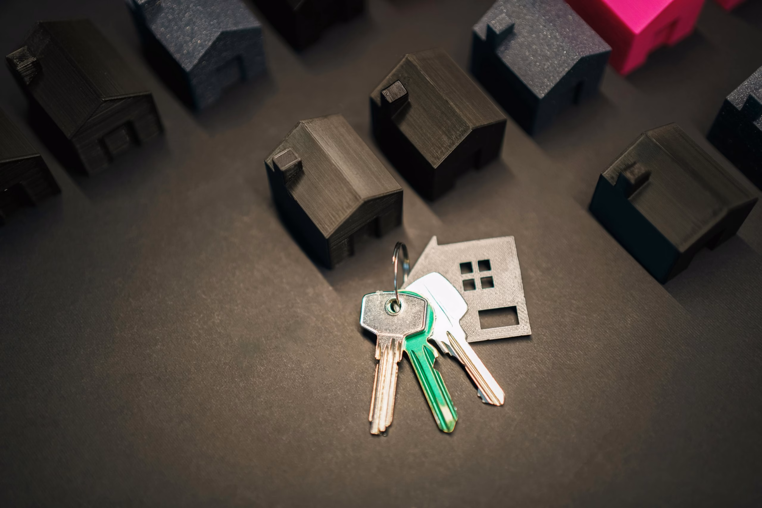Miniature house models and keys symbolize real estate investment and housing market.